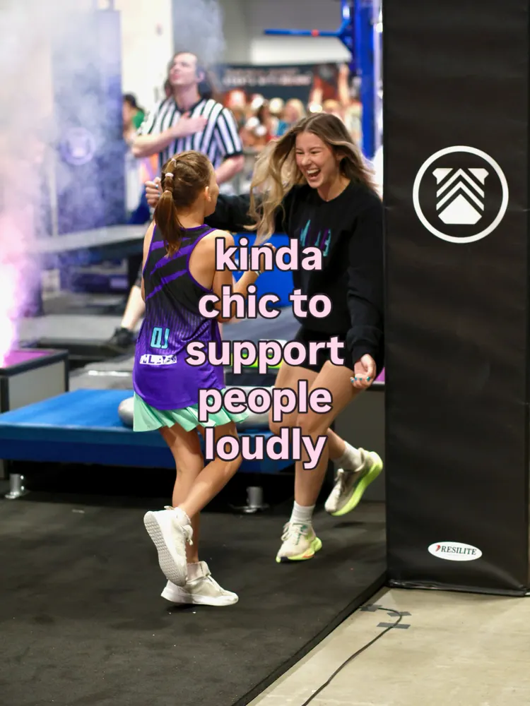 A coach in an MLAB sweatshirt laughing as she runs to hug a young athlete in a purple MLAB jersey, with the words: kinda chic to support people loudly