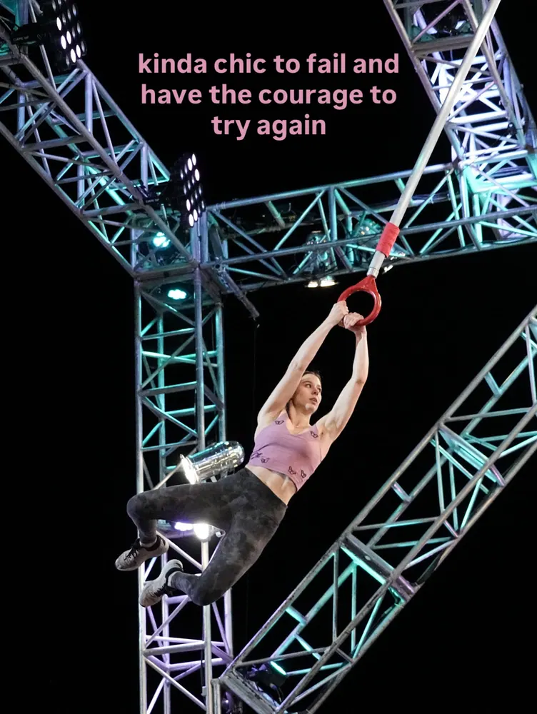 Jenn swinging from a red ring under lit-up truss, with the words: kinda chic to fail and have the courage to try again