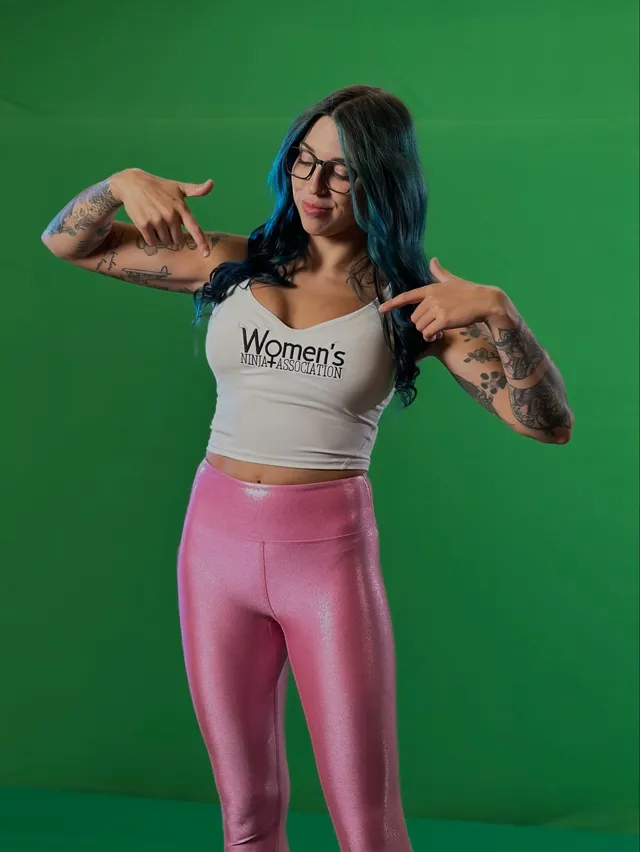 Megan Budway in a Women's Ninja Association top, pointing at the logo