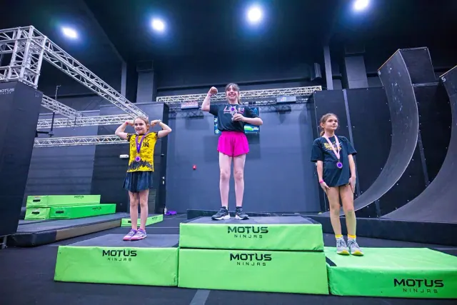 Three Kids division athletes on the podium with their medals