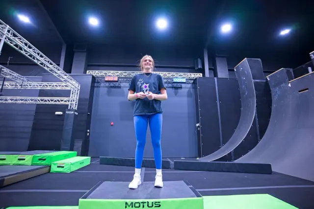 An athlete standing on the top step of the podium